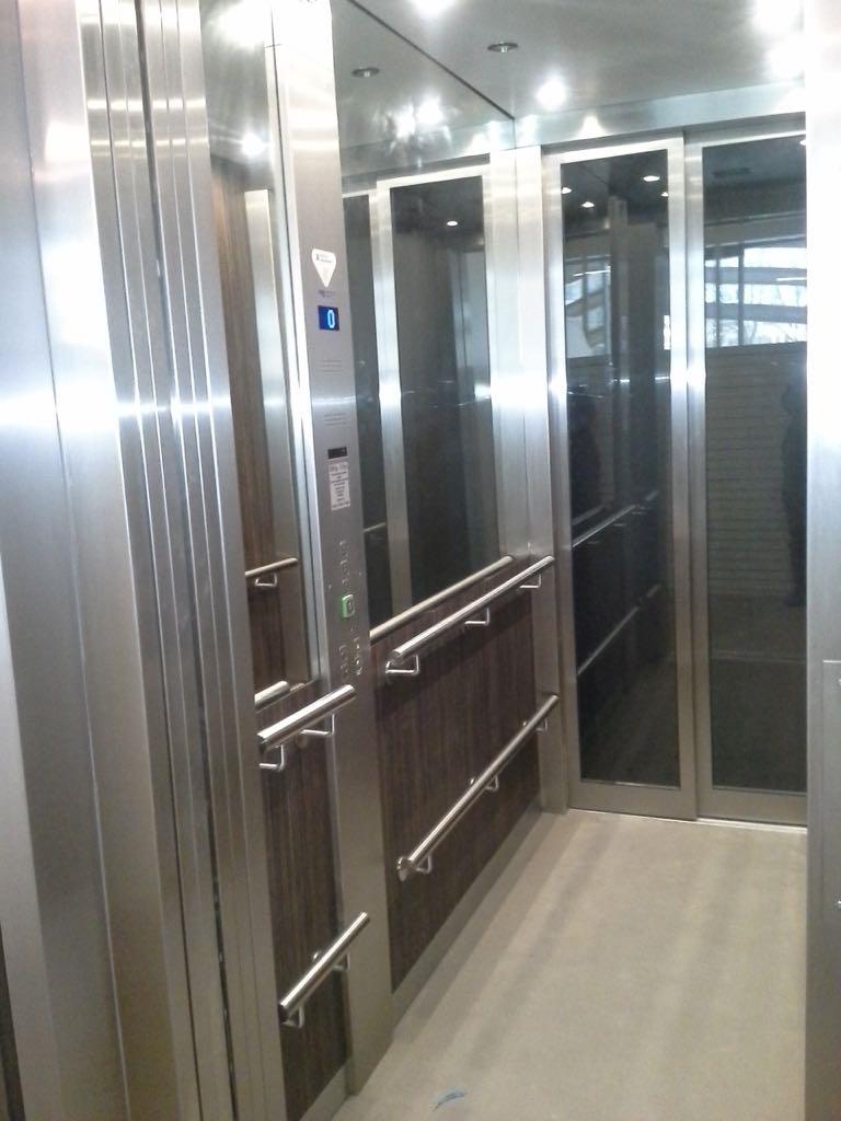 Modern liftinterieur in Rvs en houtfineer in kantorencomplex in Antwerpen